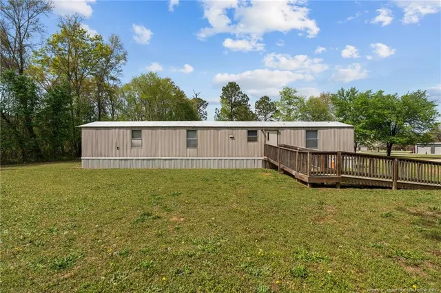 a view of a house with a garden and trees
