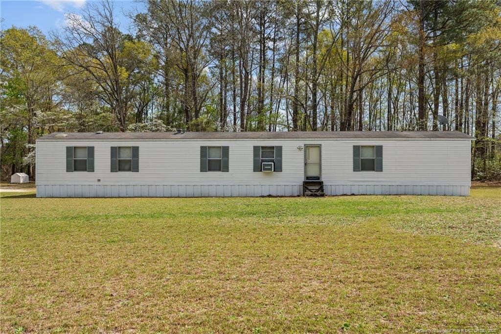 5236-5240 Maxwell Road Stedman, NC 28391 - Photo 44 of 50 a backyard of a house with large trees and brick wall
