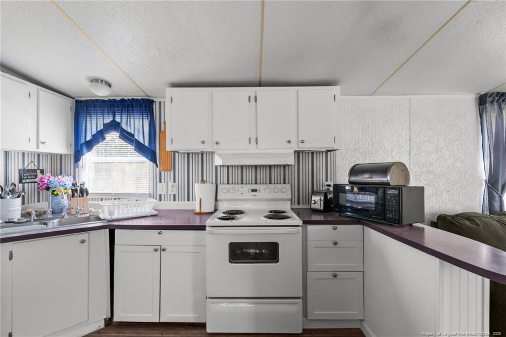 5236-5240 Maxwell Road Stedman, NC 28391 - Photo 9 of 50 a kitchen with granite countertop a stove sink and cabinets