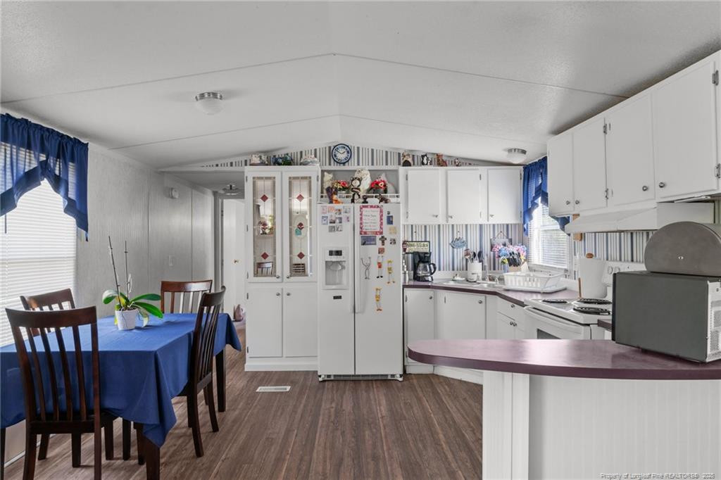 5236-5240 Maxwell Road Stedman, NC 28391 - Photo 10 of 50 a kitchen with granite countertop a refrigerator a stove a sink dishwasher and white cabinets with wooden floor