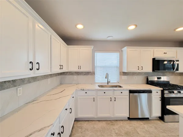a kitchen with a sink a stove and cabinets