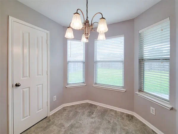 a view of empty room with window and wooden floor