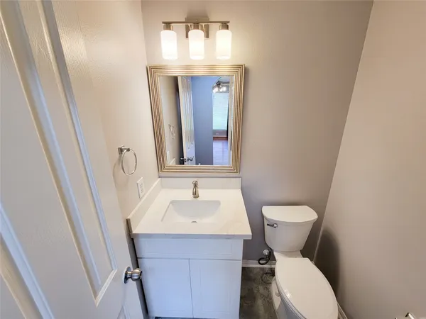 a bathroom with a sink and mirror with toilet
