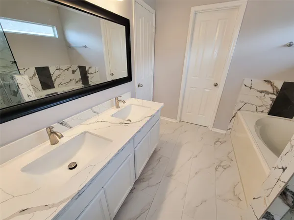 a bathroom with a tub sink and mirror