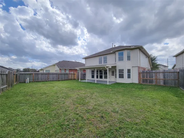 a view of a big house with a big yard and large trees