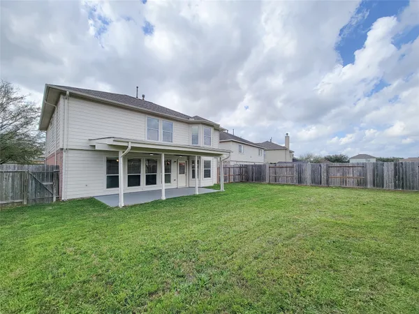 a view of a house with a big yard and large trees