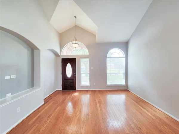 a view of a room with wooden floors and chandelier