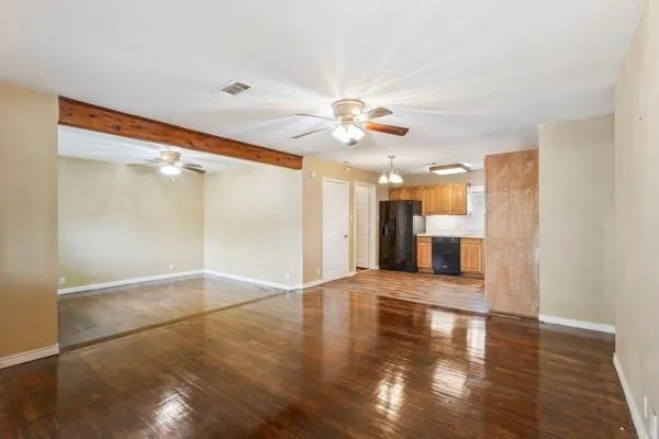 a view of an empty room with window and wooden floor