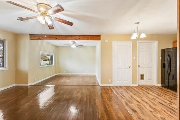 a view of a room with wooden floor a ceiling fan and closet