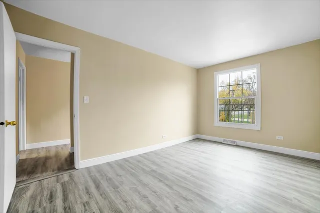 a view of an empty room with wooden floor