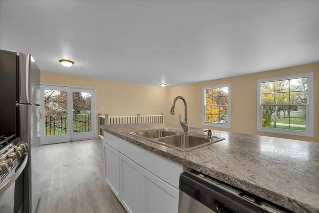 a kitchen with stainless steel appliances granite countertop a refrigerator sink and stove