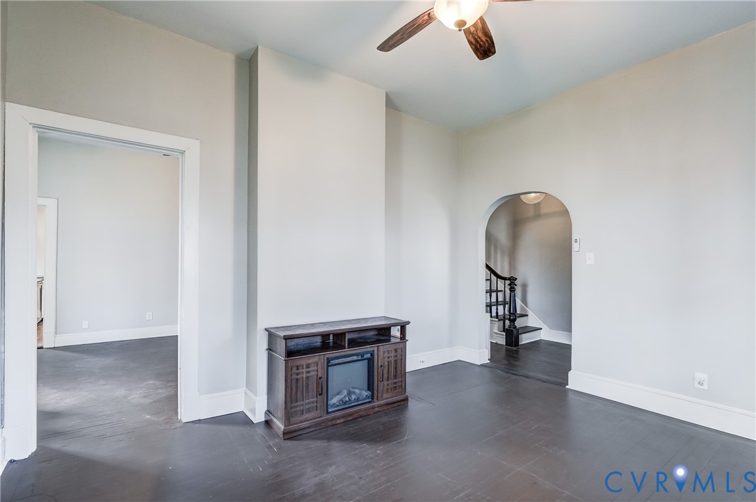 418 4th Street West Point, VA 23181 - Photo 8 of 36 an empty room with a fireplace and wooden floor