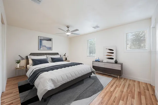 a bedroom with a bed and wooden floor