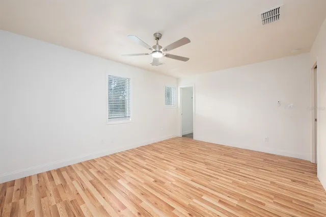 a view of a big room with wooden floor and a ceiling fan