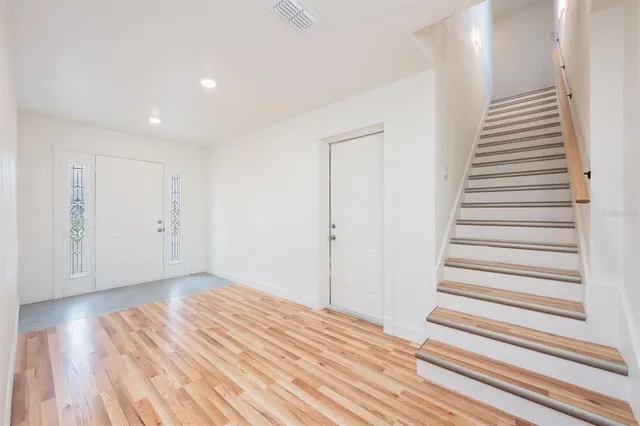 a view of a room with wooden floor and white walls