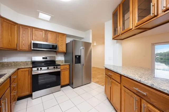 a kitchen with stainless steel appliances granite countertop a stove a sink and a microwave