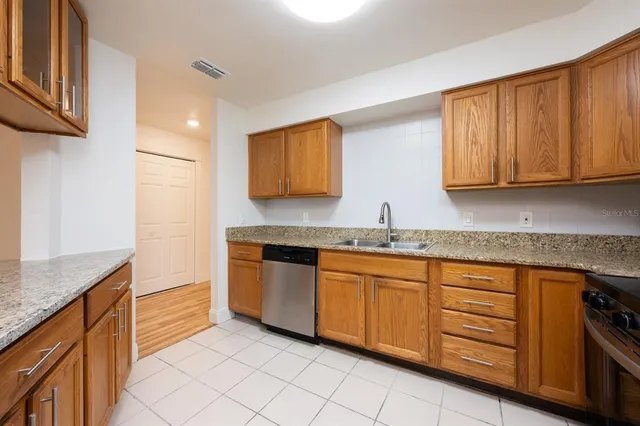 a kitchen with granite countertop cabinets sink and stove