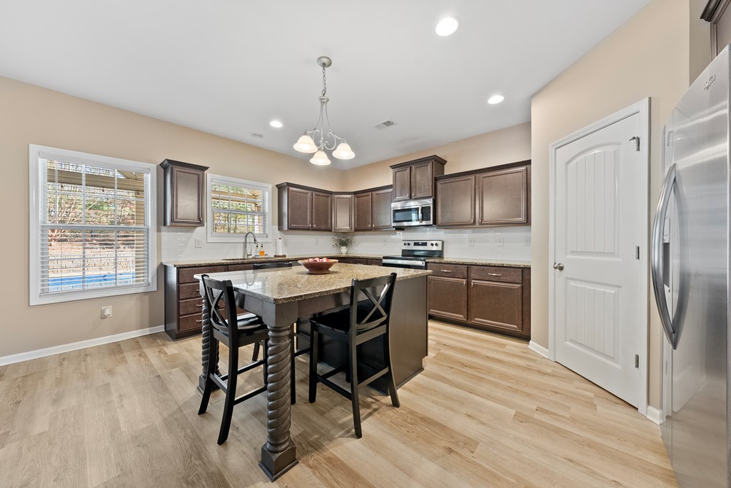 67 Pin Oak Way Hamilton, GA 31811 - Photo 12 of 65 a kitchen with kitchen island granite countertop wooden floors appliances and furniture