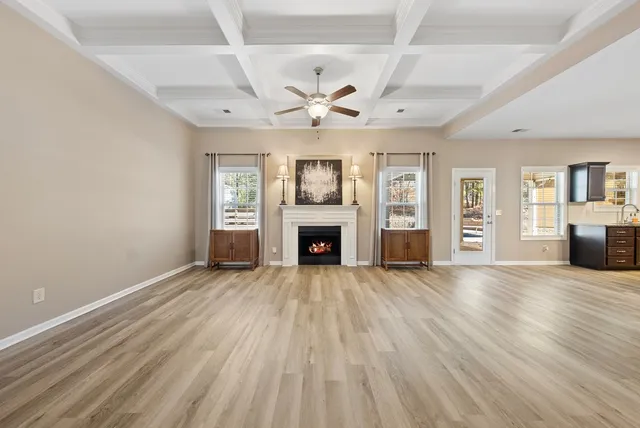 wooden floor fireplace and windows in an empty room
