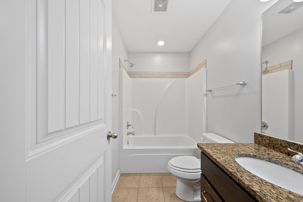 67 Pin Oak Way Hamilton, GA 31811 - Photo 41 of 65 a bathroom with a granite countertop toilet a sink and a bathtub