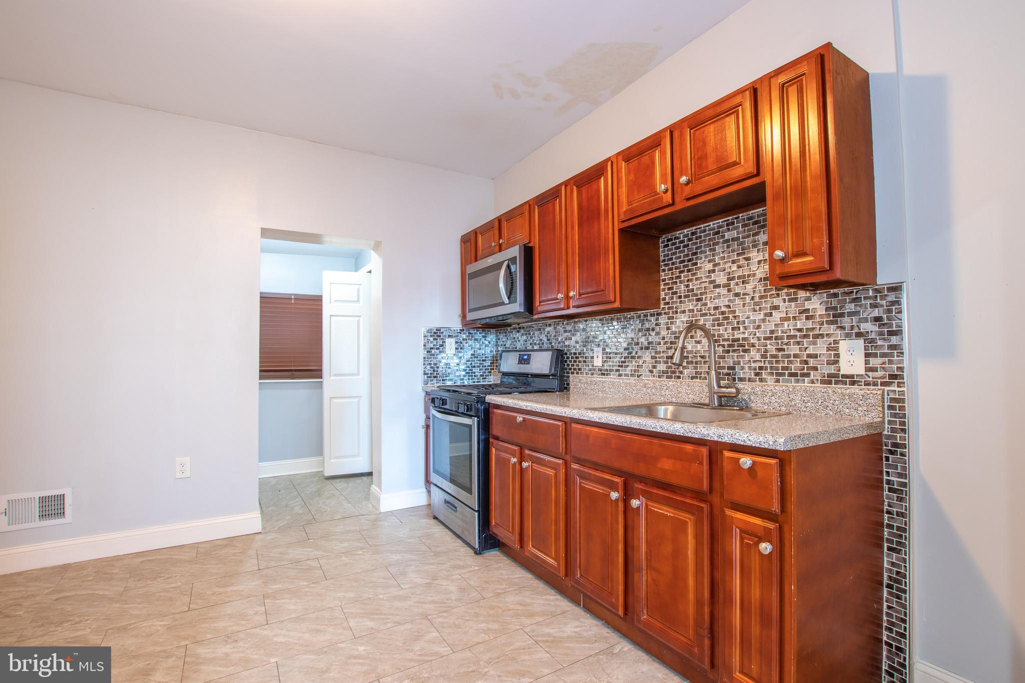 2707 Morris Street Philadelphia, PA 19145 - Photo 7 of 26 a kitchen with stainless steel appliances granite countertop a sink stove and cabinets