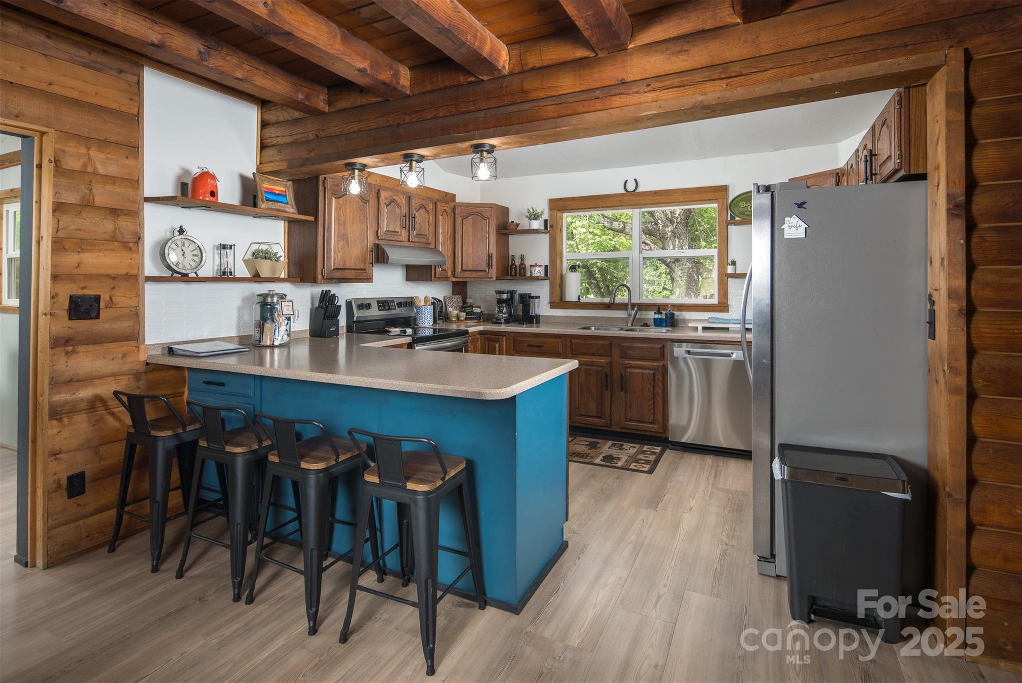 1090 Horse Bottom Road Banner Elk, NC 28604 - Photo 7 of 30 a kitchen with kitchen island granite countertop wooden floors and stainless steel appliances