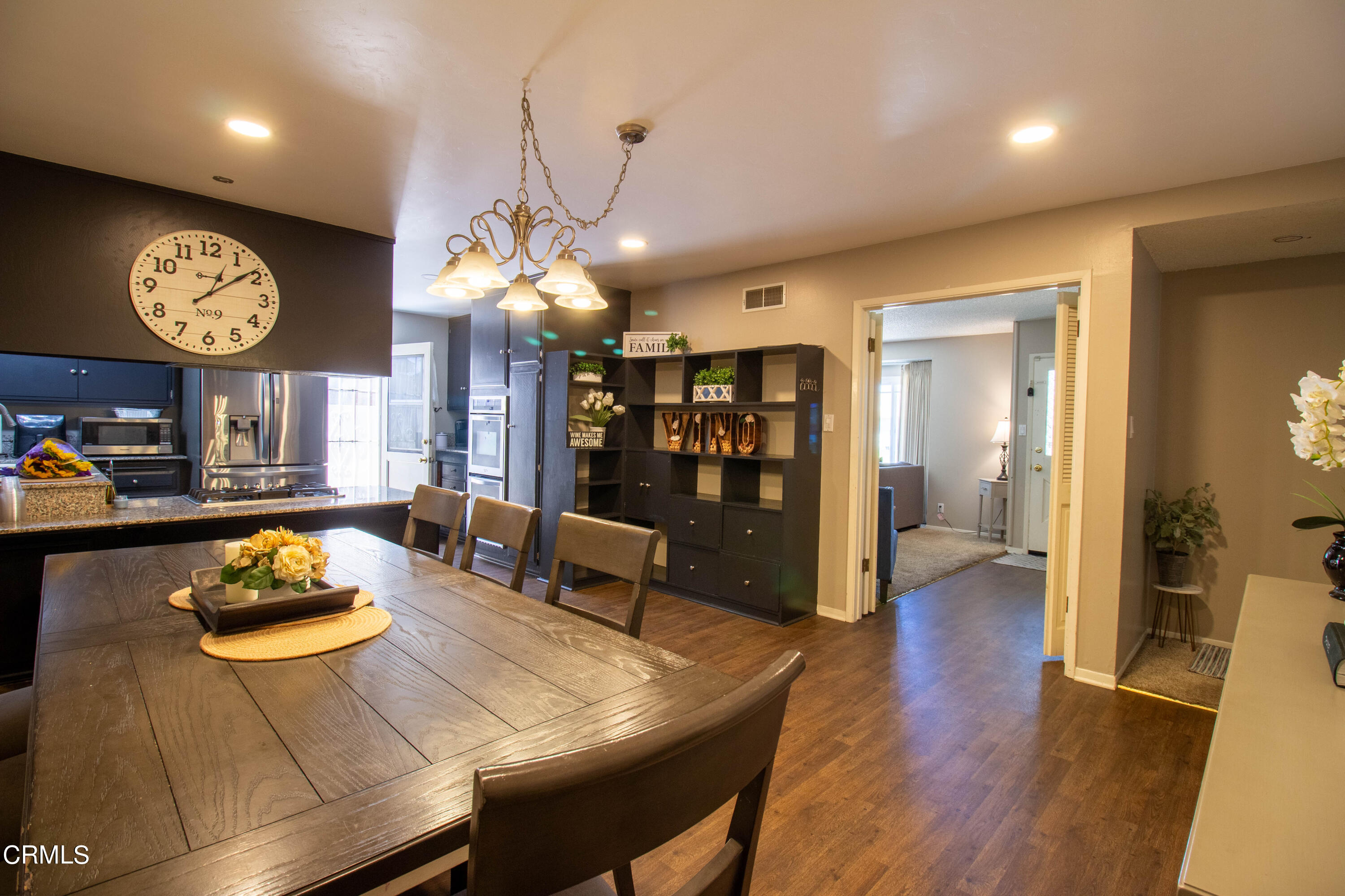 1300 Bluebell Street Oxnard, CA 93036 - Photo 21 of 24 a view of a dining room and livingroom with furniture wooden floor a chandelier