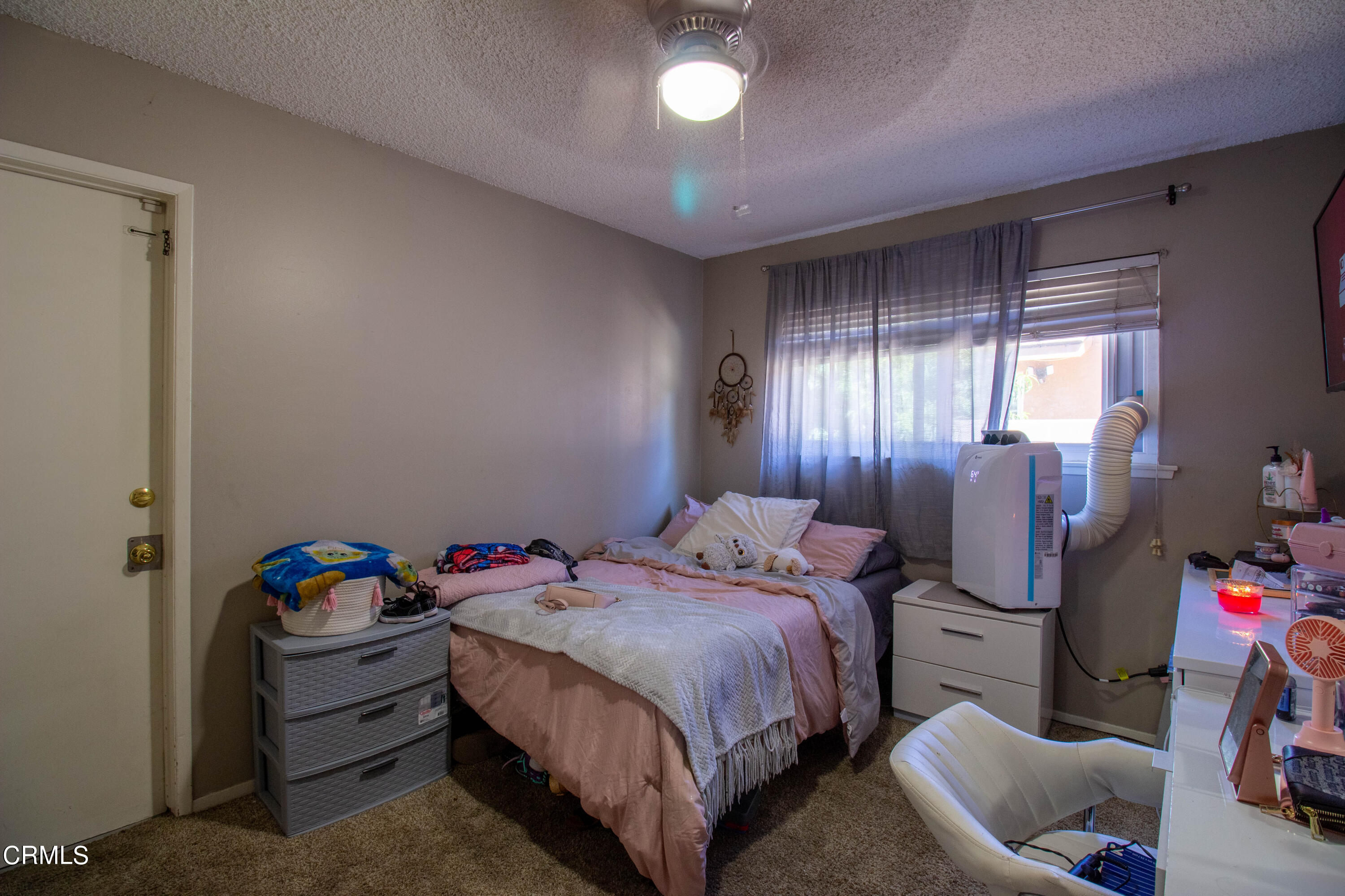 1300 Bluebell Street Oxnard, CA 93036 - Photo 9 of 24 a bedroom with a bed and a chandelier