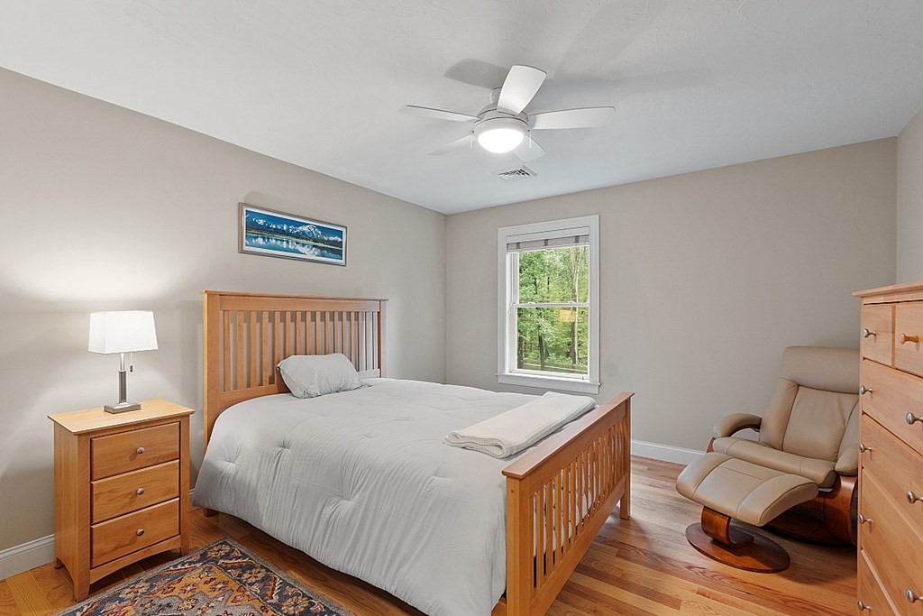 24 Little Turnpike Road Shirley, MA 01464 - Photo 16 of 42 a bedroom with a bed and a chandelier