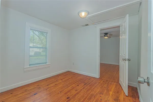 an empty room with wooden floor and a window
