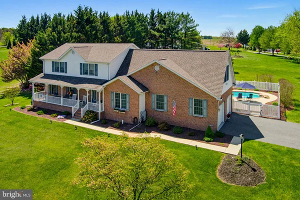 a aerial view of a house with a yard table and chairs