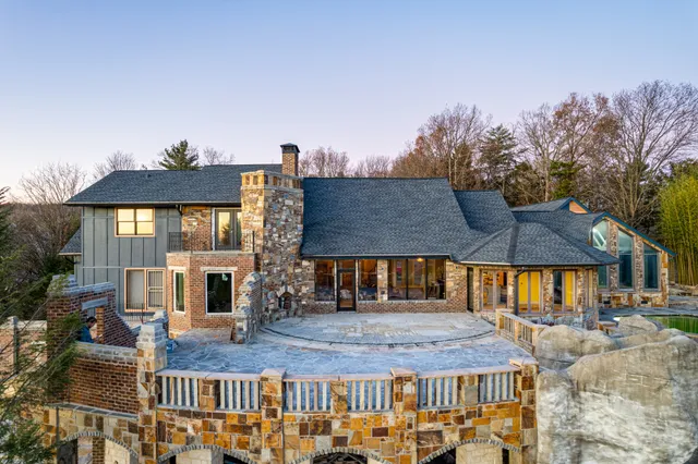 a view of a patio with couches table and chairs under an umbrella with a barbeque grill and couches