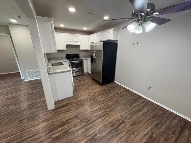 a view of kitchen with refrigerator microwave and cabinets