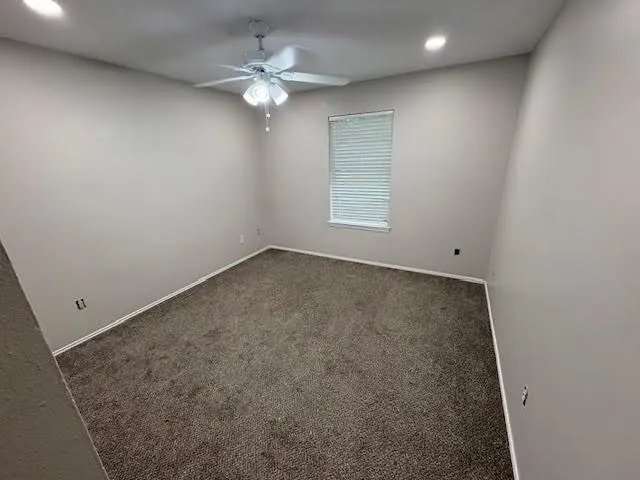 an empty room with chandelier fan