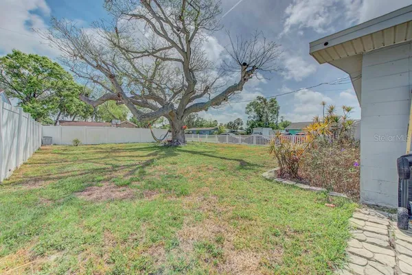 a view of yard with tree in the background