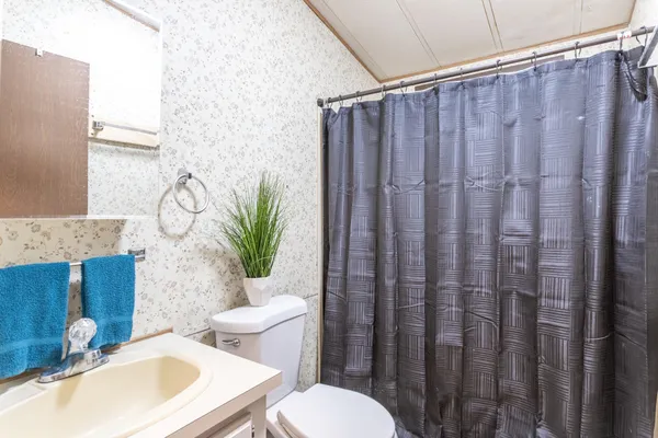 a bathroom with a granite countertop toilet and a sink