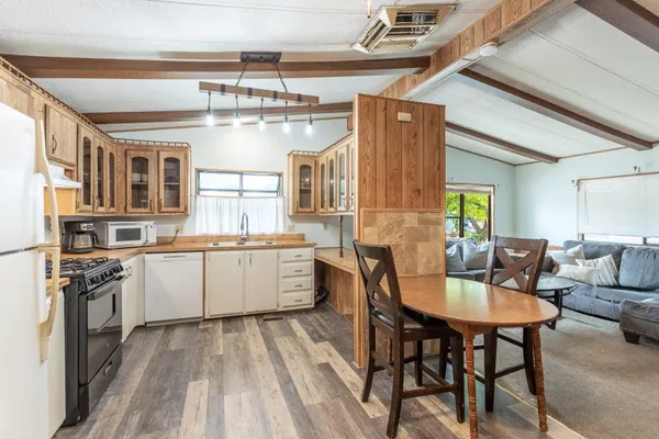 a kitchen with a dining table chairs stainless steel appliances and cabinets