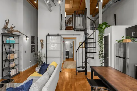 a living room with furniture a fireplace and wooden floor
