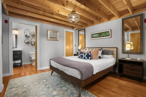 a bedroom with a bed and a dresser next to a window