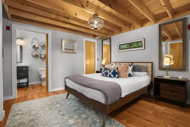 a bedroom with a bed and a dresser next to a window