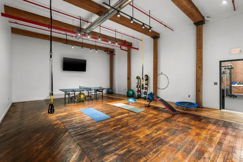 a room with wooden floor and flat screen tv