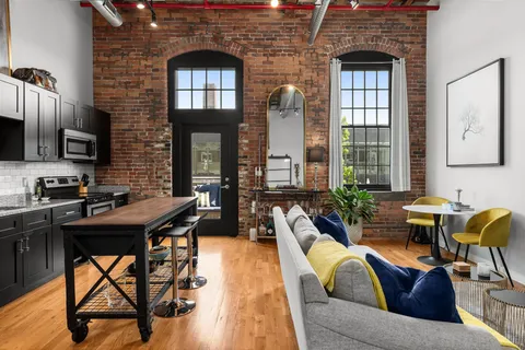 a living room with furniture a chandelier and a piano