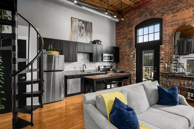 a living room with stainless steel appliances kitchen island granite countertop furniture and a kitchen view