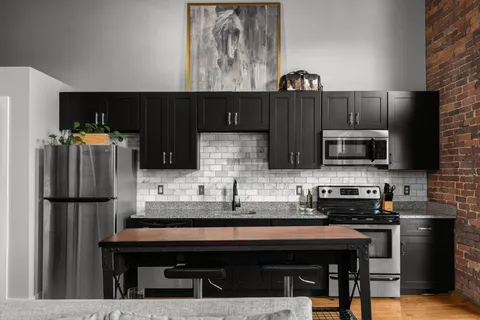 a kitchen with stainless steel appliances a sink cabinets and a refrigerator