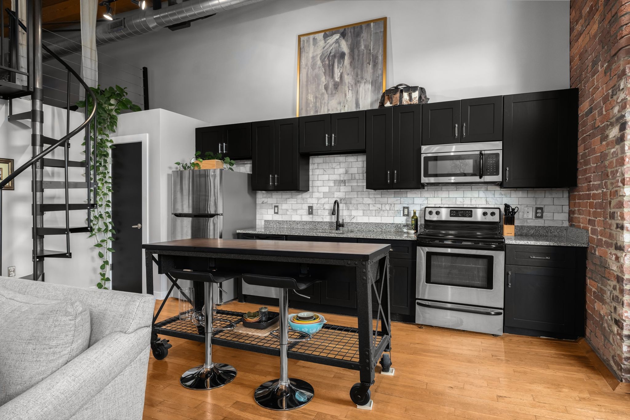 1350 Rosa L Parks Boulevard, Unit 463 Nashville, TN 37208 - Photo 10 of 44 a kitchen with stainless steel appliances kitchen island granite countertop a table chairs sink and cabinets