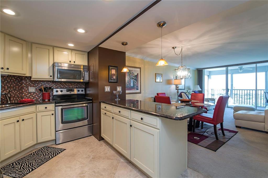 3 Bluebill Avenue, Unit 704 Naples, FL 34108 - Photo 2 of 12 a kitchen with stainless steel appliances granite countertop a stove sink and cabinets