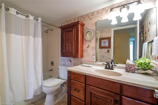 a bathroom with a sink vanity mirror and toilet