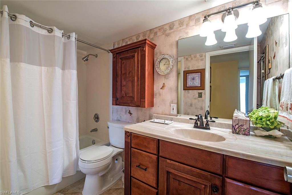3 Bluebill Avenue, Unit 704 Naples, FL 34108 - Photo 9 of 12 a bathroom with a sink vanity mirror and toilet