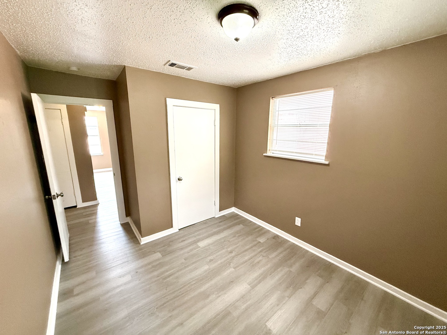 1827 East Highland Boulevard San Antonio, TX 78210 - Photo 11 of 17 an empty room with wooden floor and windows