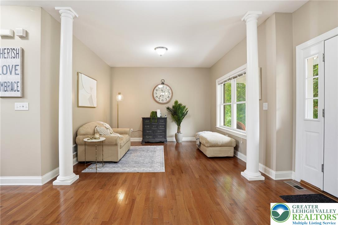 1212 Miller Road Wind Gap, PA 18091 - Photo 6 of 72 Warm hardwood flooring flows throughout this luminous living area, featuring decorative columns and ample natural light.